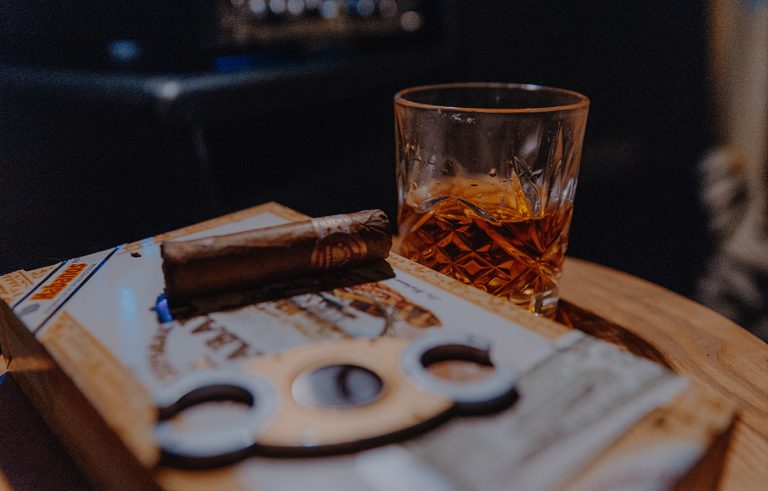 Playing poker with whiskey and cigars on table